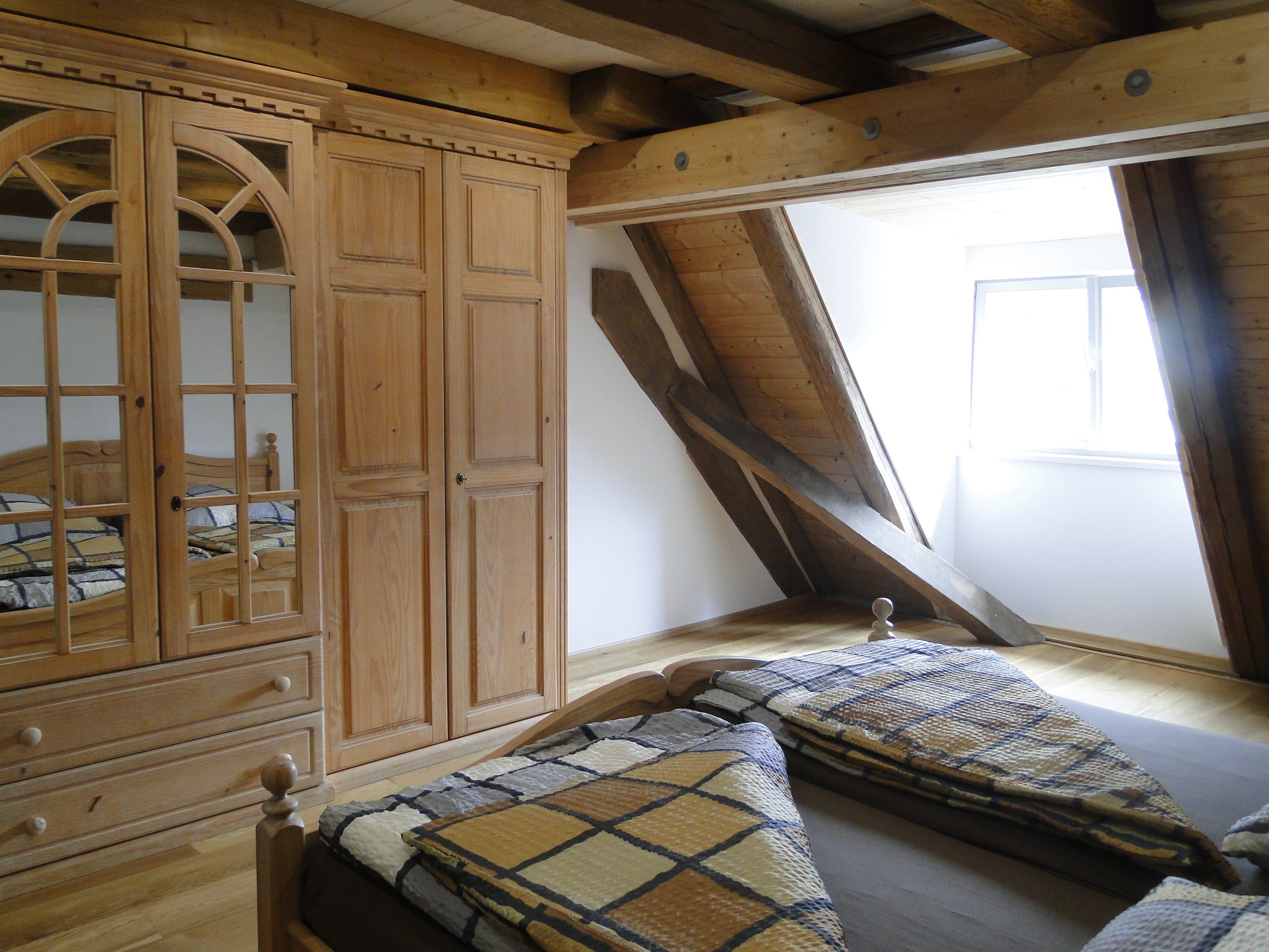 Schlafzimmer mit Doppelbett und Holzschrank